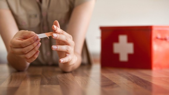 Person putting bandage on their finger.