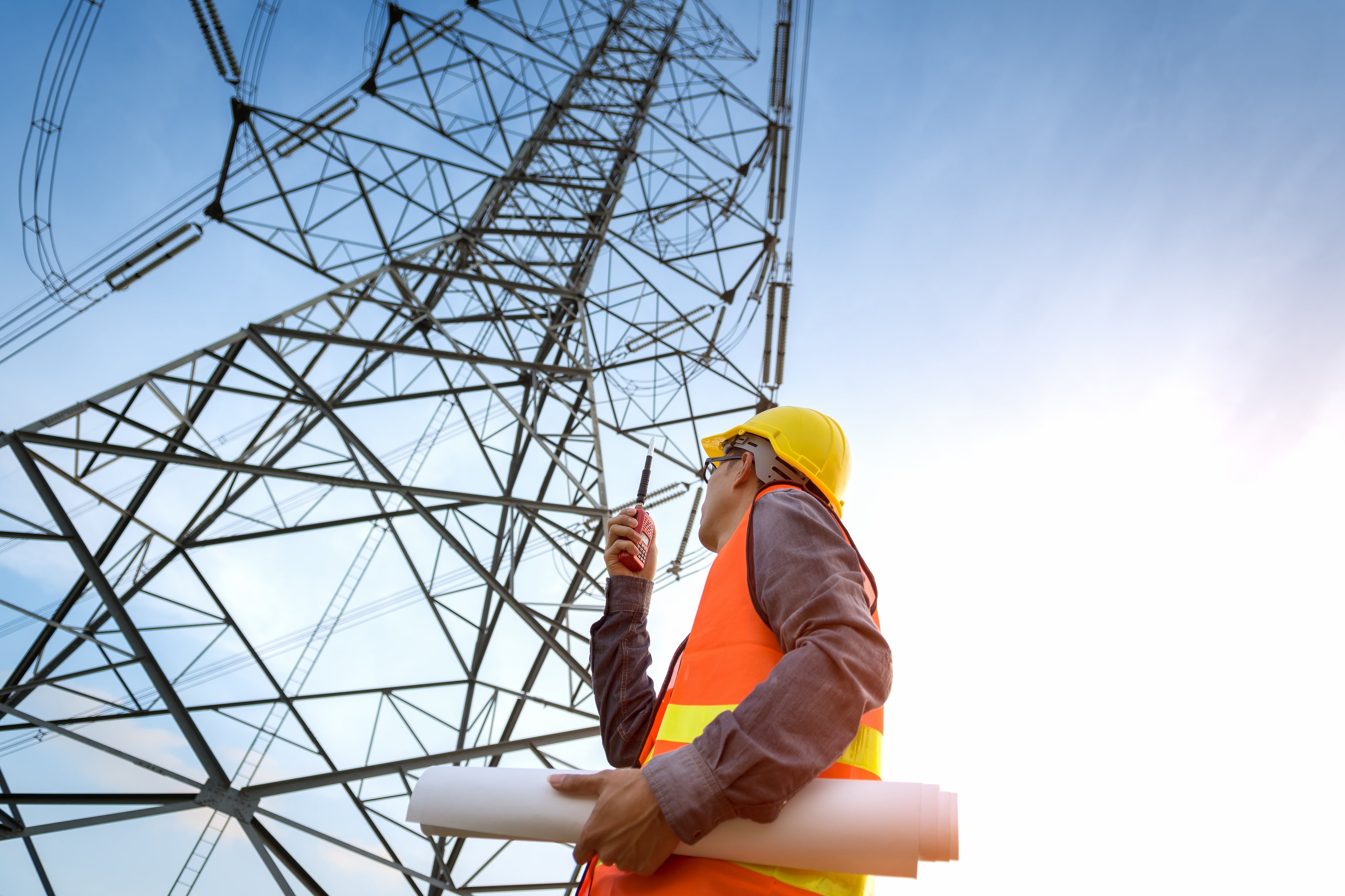 Construction worker inspecting electric line. 