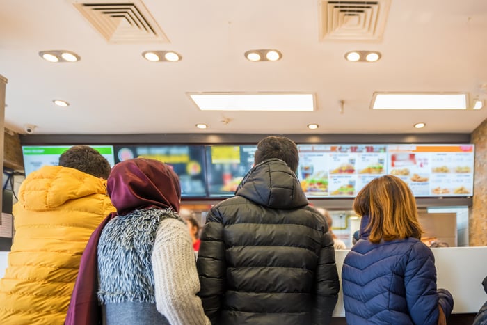 Customers wait in line at a fast food restaurant.