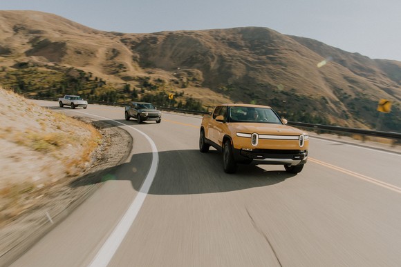 Rivian trucks on highway.