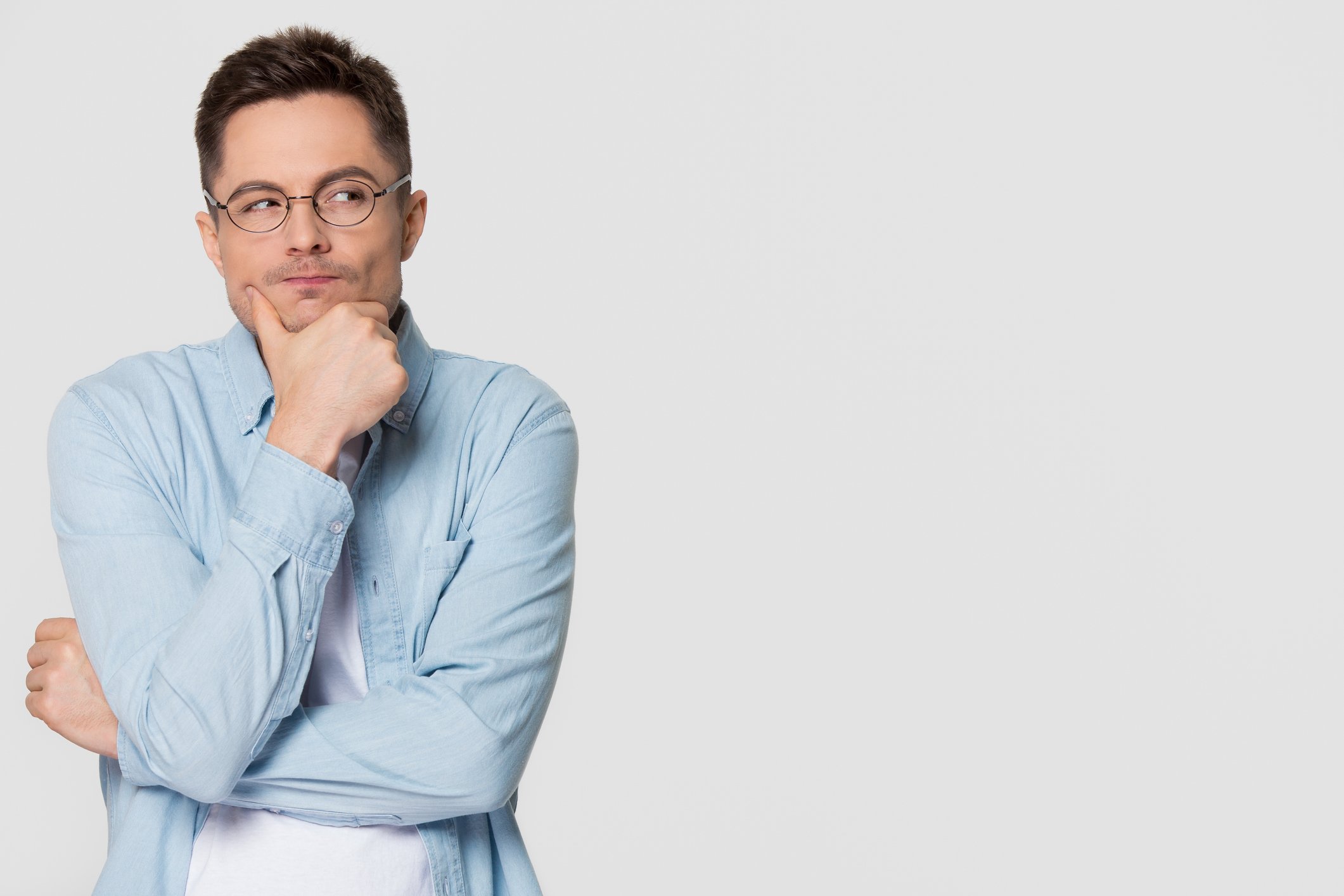 Someone with their arms crossed and hand on their chin making a thinking face.