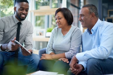 An advisor showing a tablet to a couple.