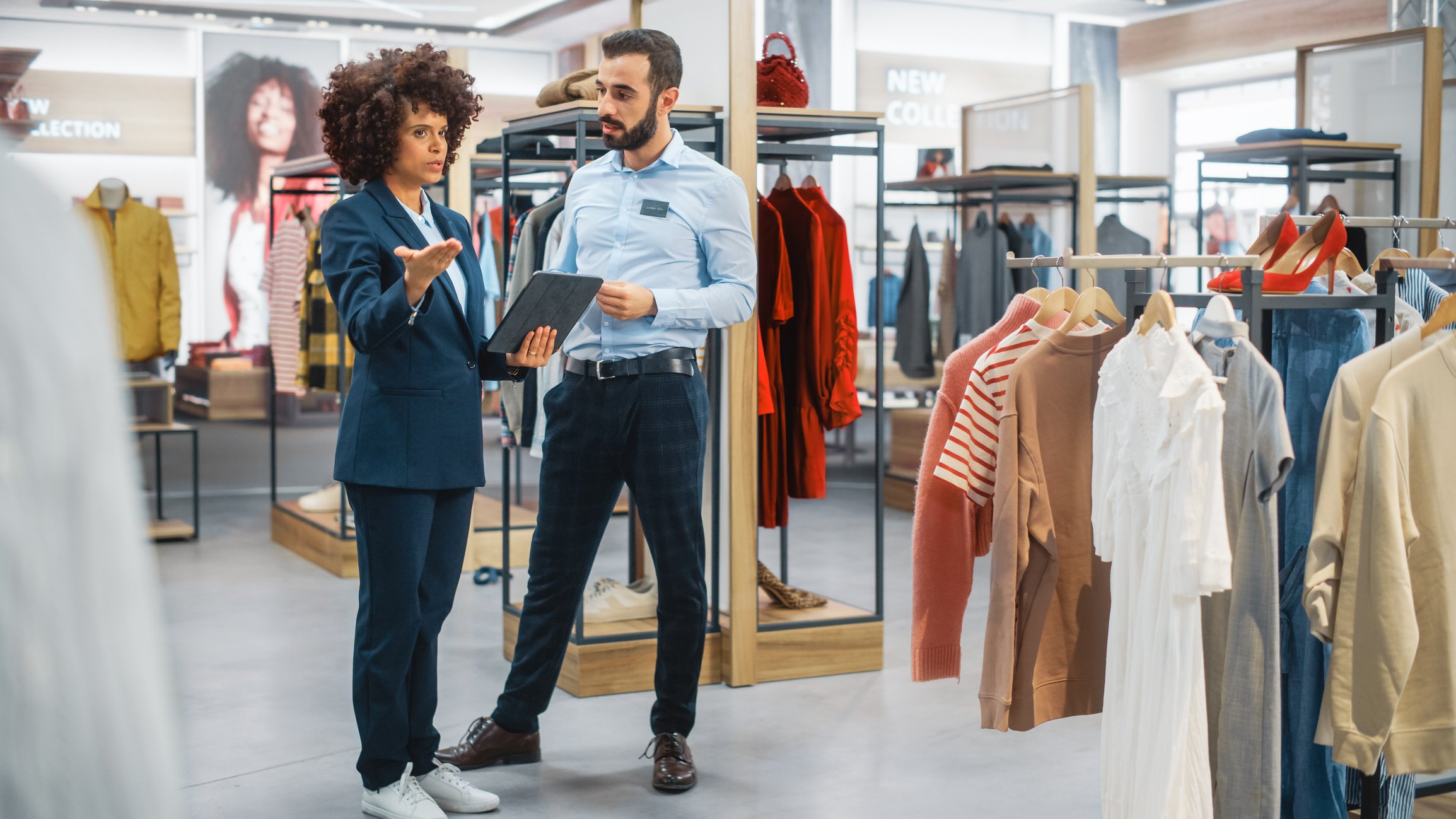 Two people talking in a clothing store.