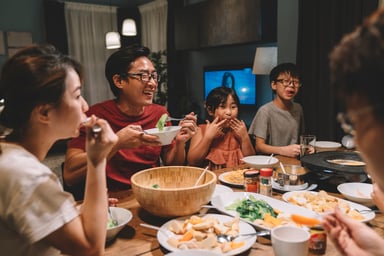 family laughing during dinner at home