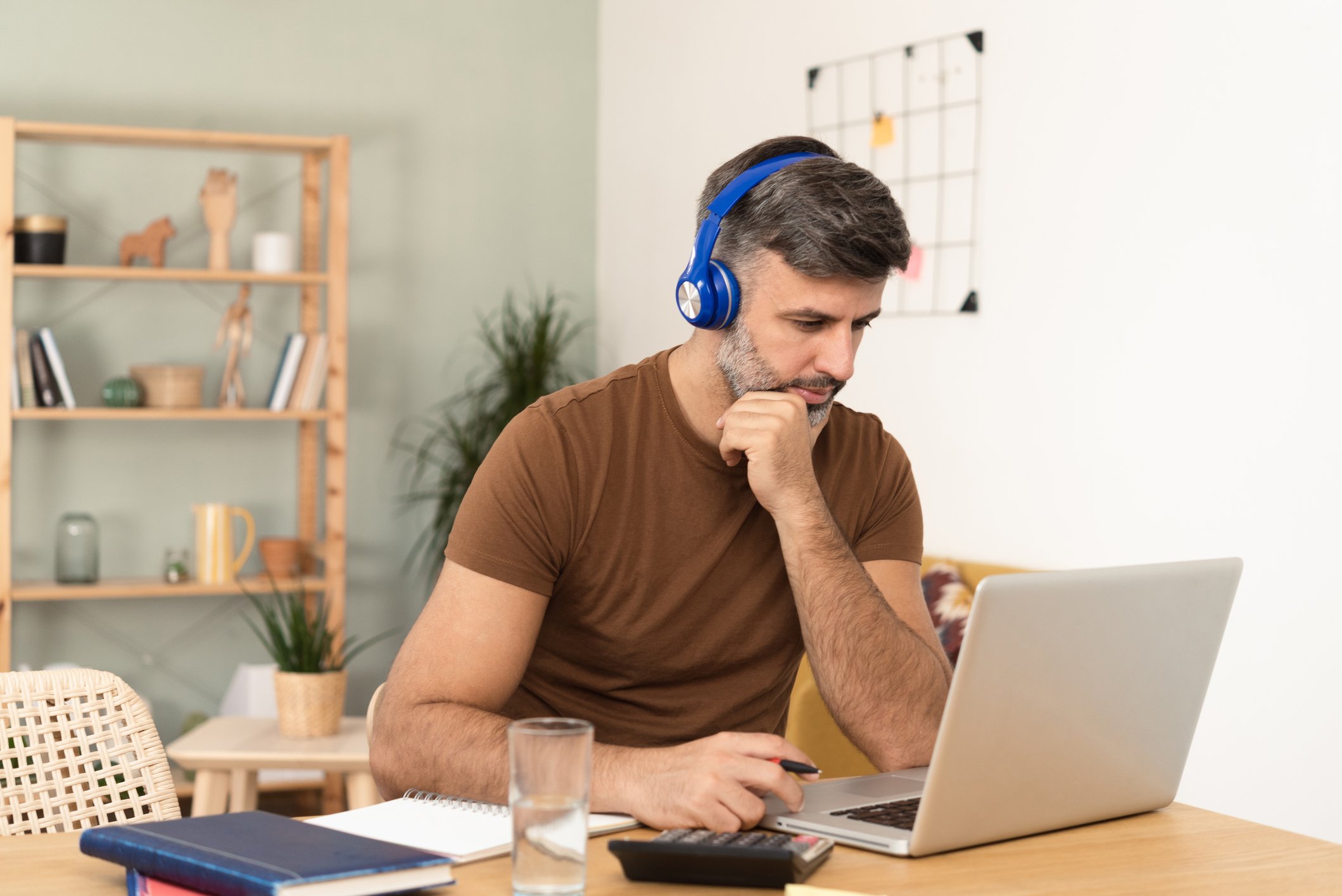 A person wearing headphones while sitting at a laptop.