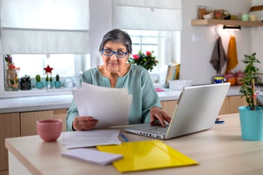 A person at desk, looking at documents and data.