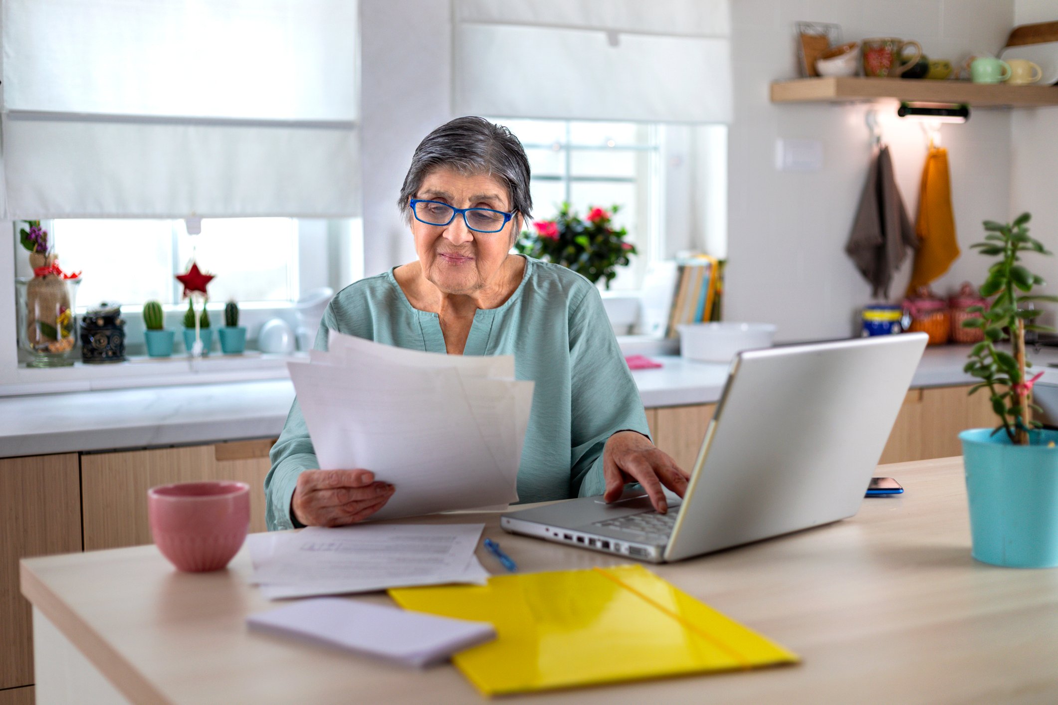A person at desk, looking at documents and data.