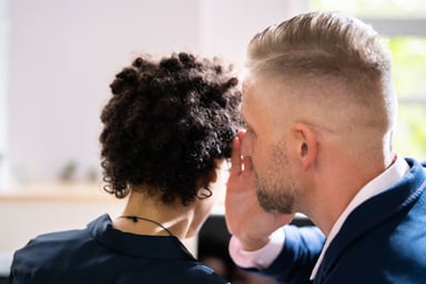 One businessperson whispers something to another.
