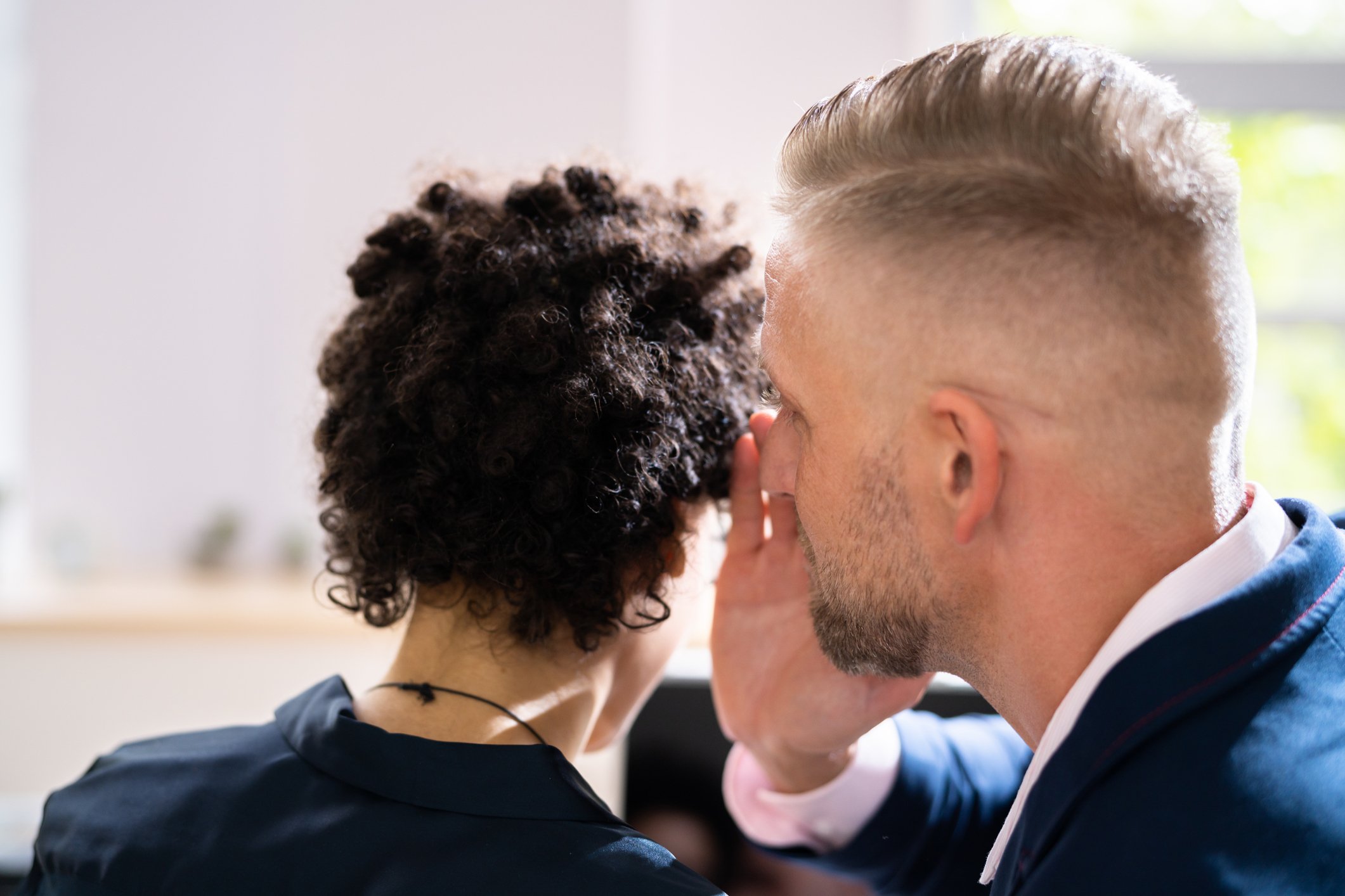 One businessperson whispers something to another.