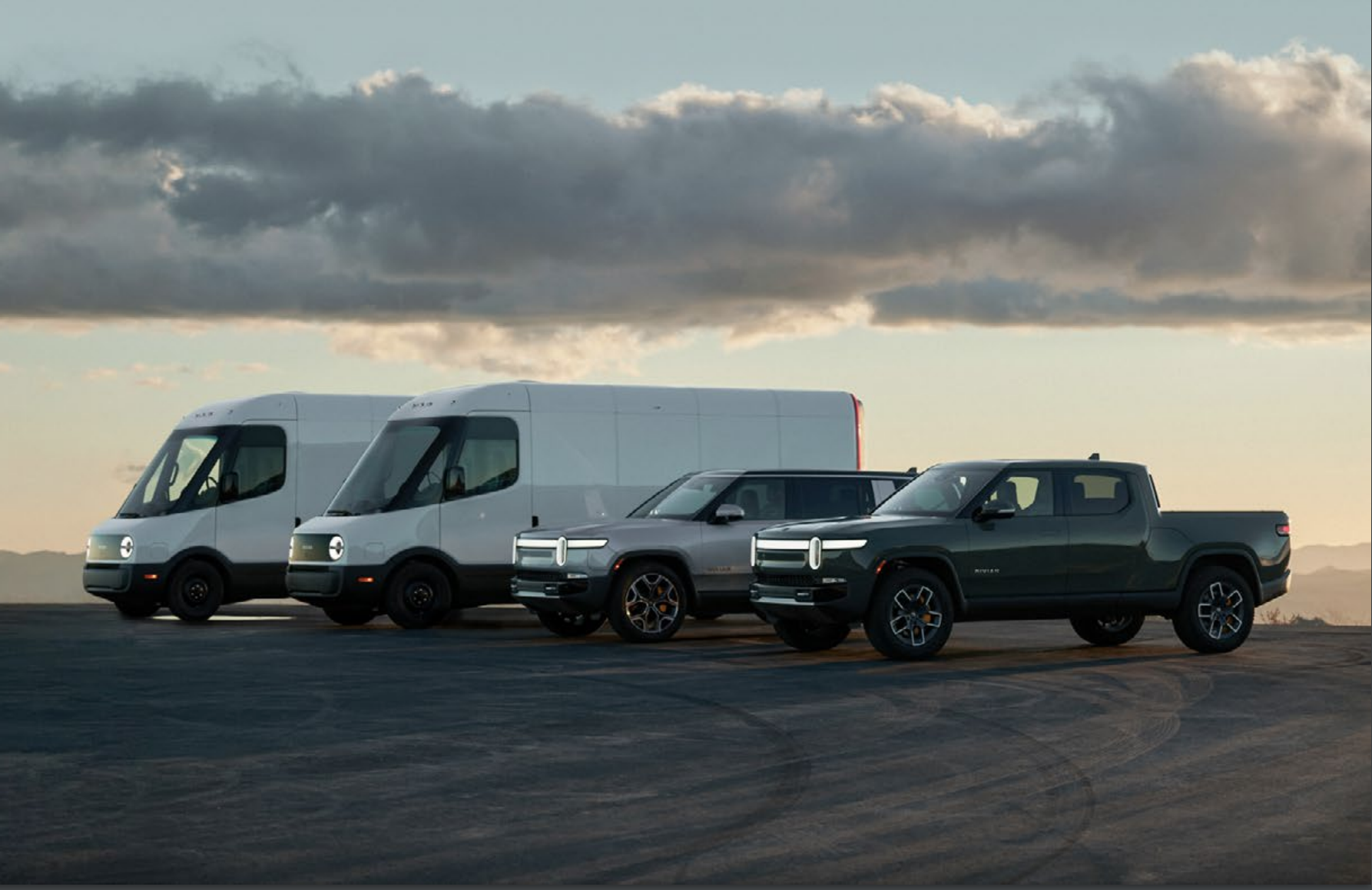 A lineup of Rivian commercial vans, pickup truck, and SUV.