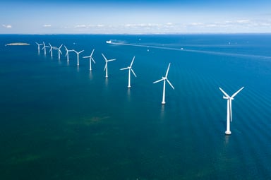 line of wind turbines in the ocean