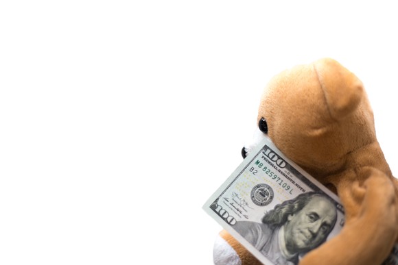 Teddy bear holding $100 bill.