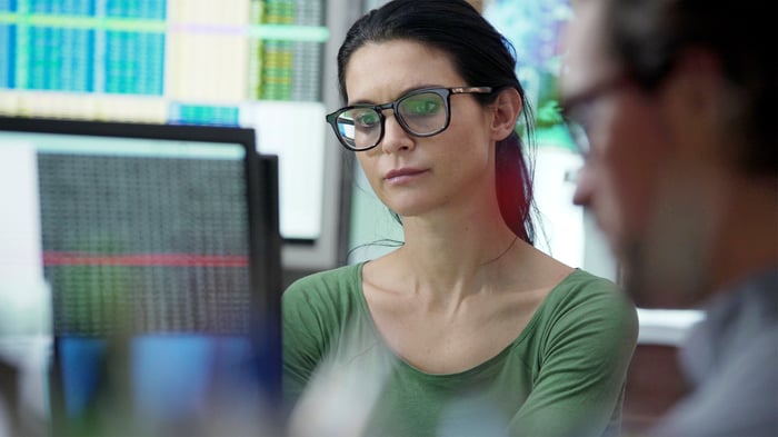 Two business people looking at data on screens. 