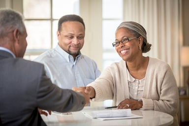 A couple shaking hands with an advisor.