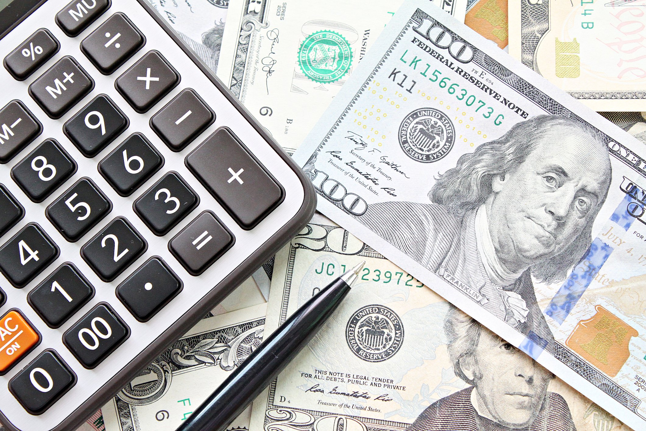 calculator and pen on American Dollars cash money