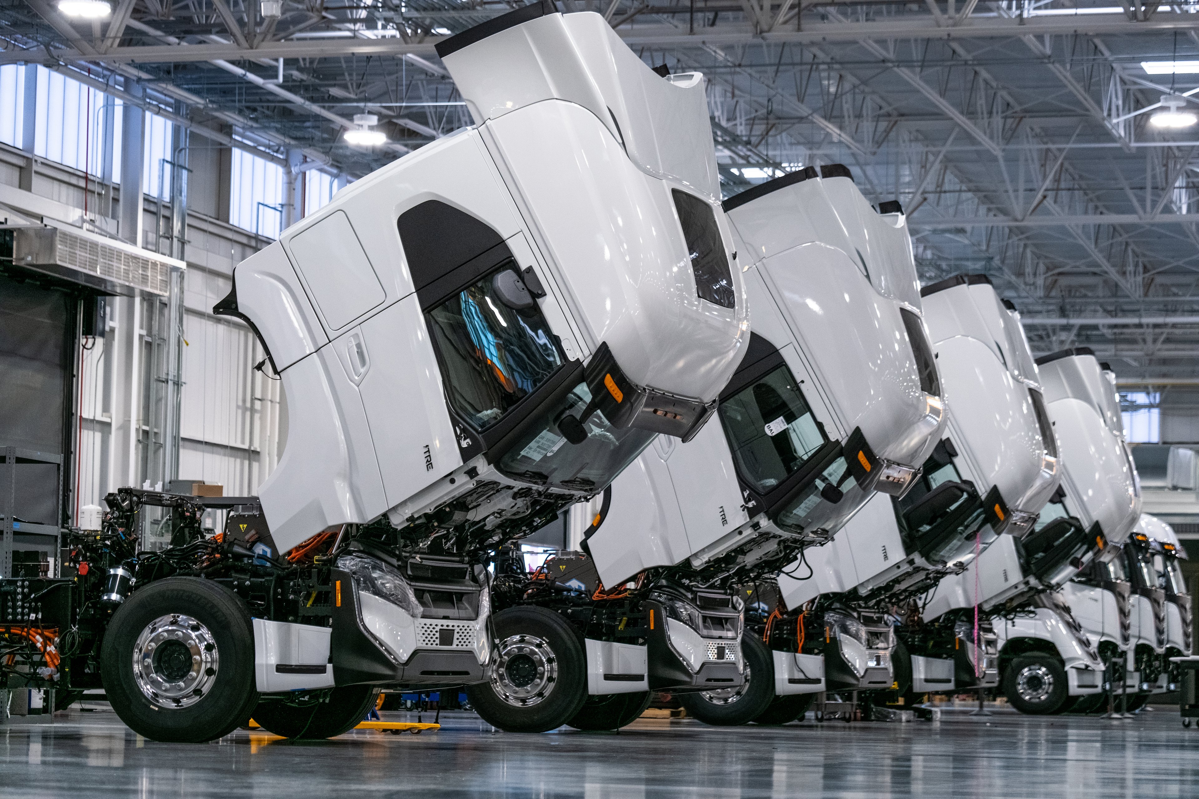 Nikola electric semi trucks in production warehouse.