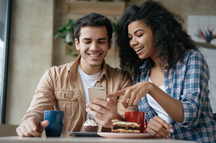 Two people looking at a smartphone.