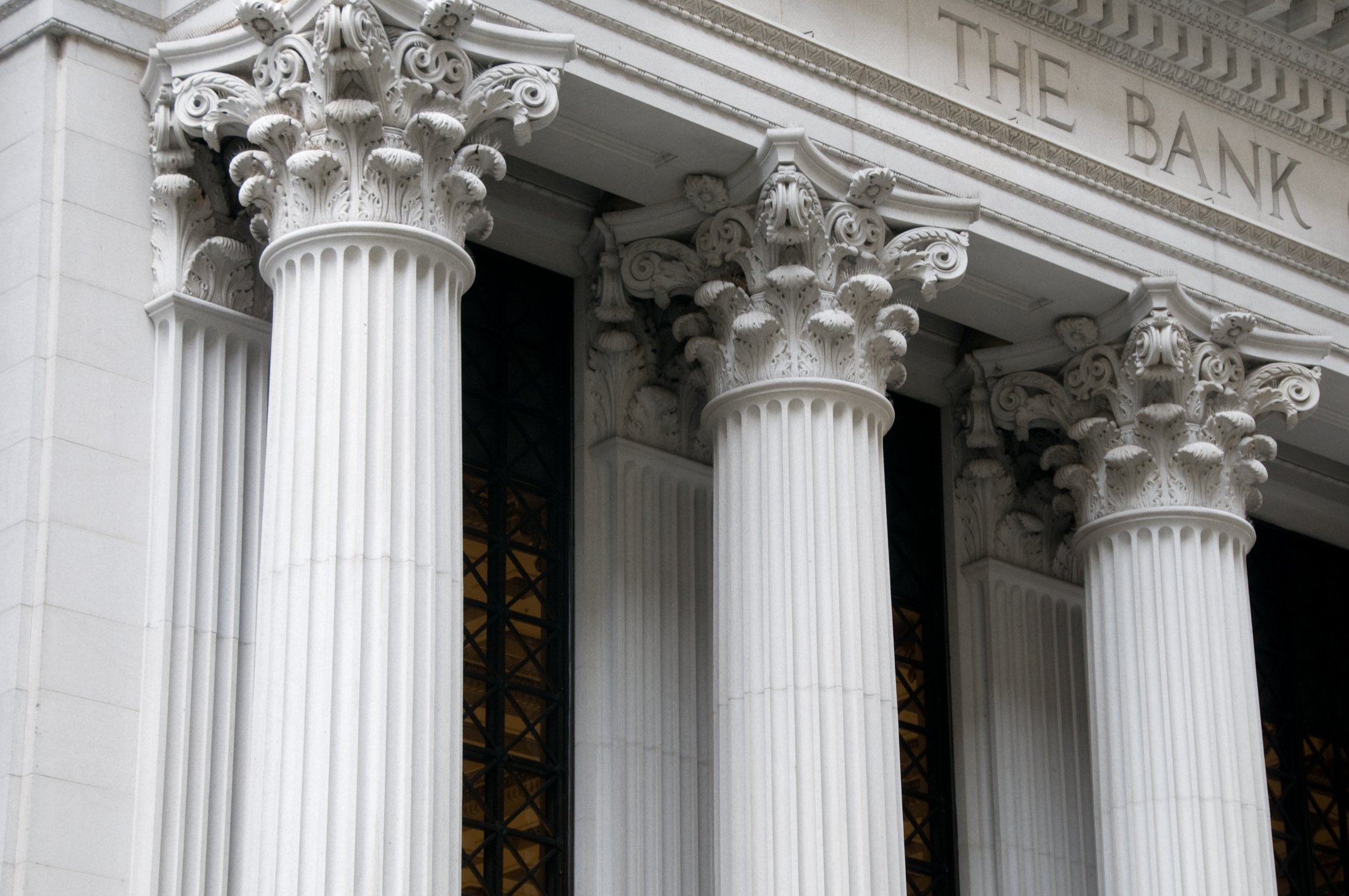 Columns outside a marble building that says The Bank. 