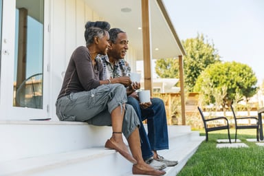 two people sitting on a porch outside