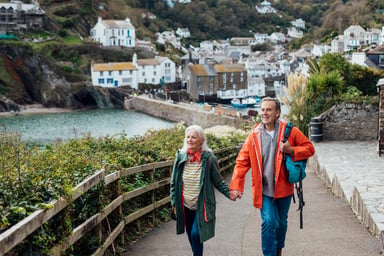 Two people walking on a path leading from a town