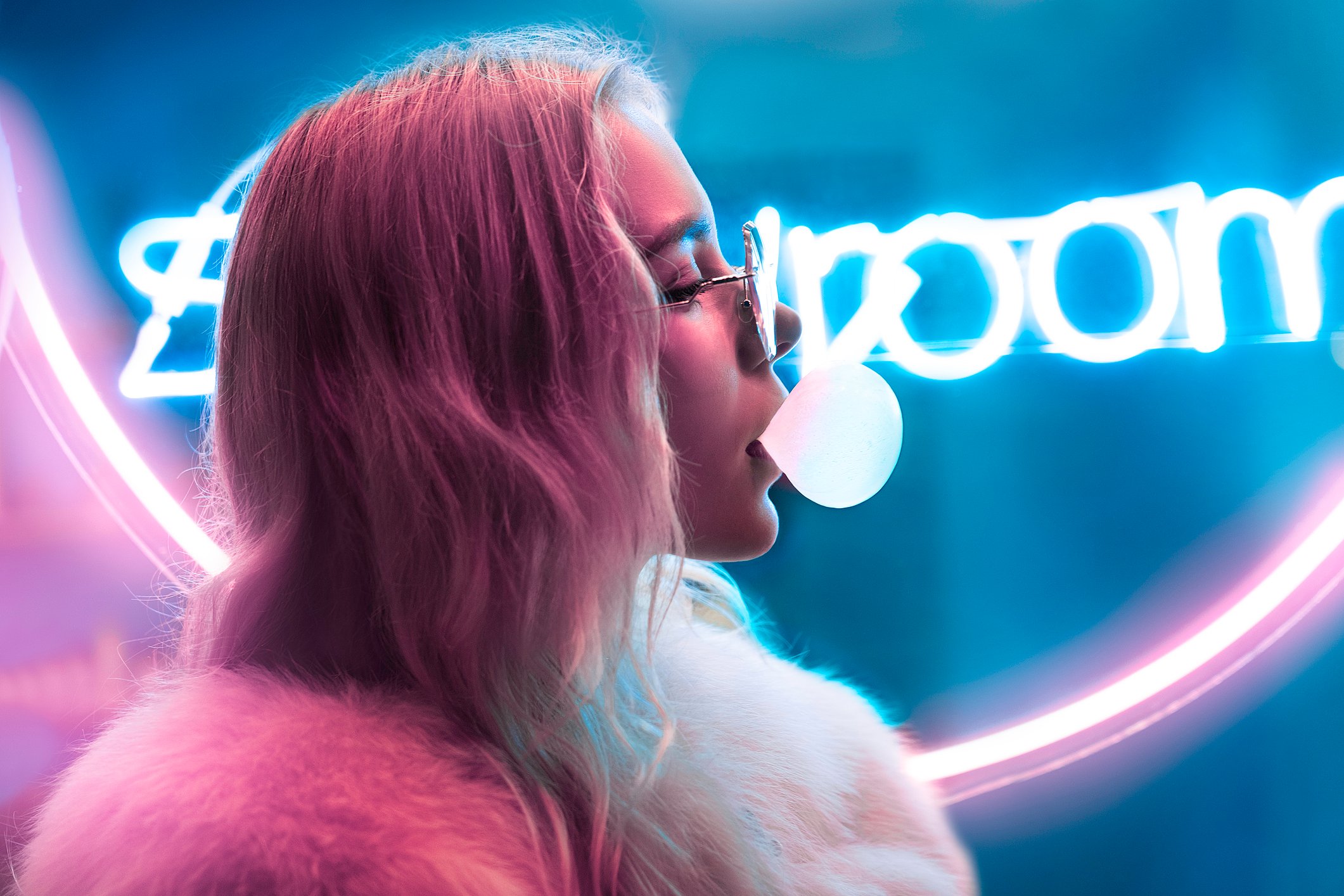 A young person chews some bubble gum.