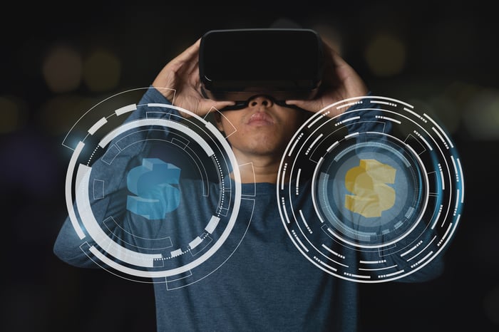 A person looking through virtual reality goggles with an image showing dollar signs.