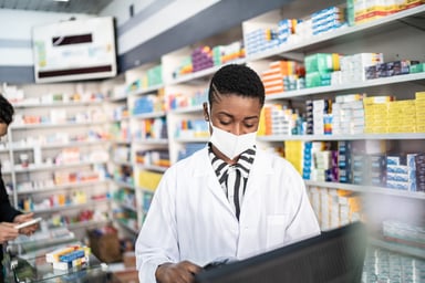 pharmacist consults tablet in pharmacy