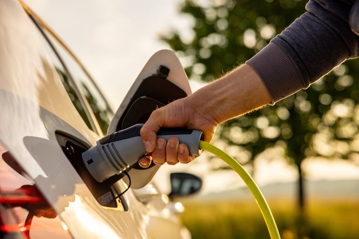 A person holding an EV plug.