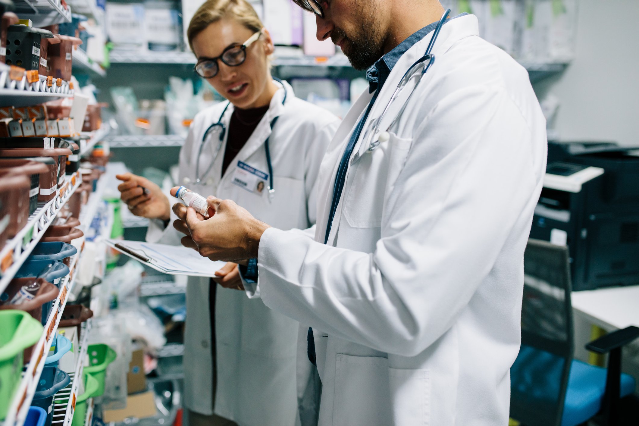 pharmacists looking at pills in bottle