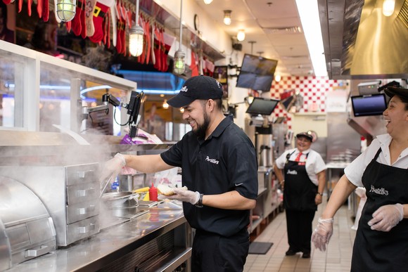 Portillo's employees in kitchen preparing food.