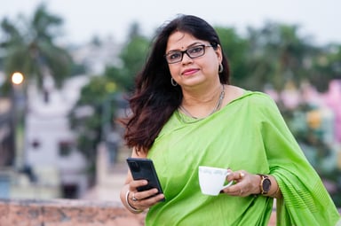 drinking tea and using her smartphone