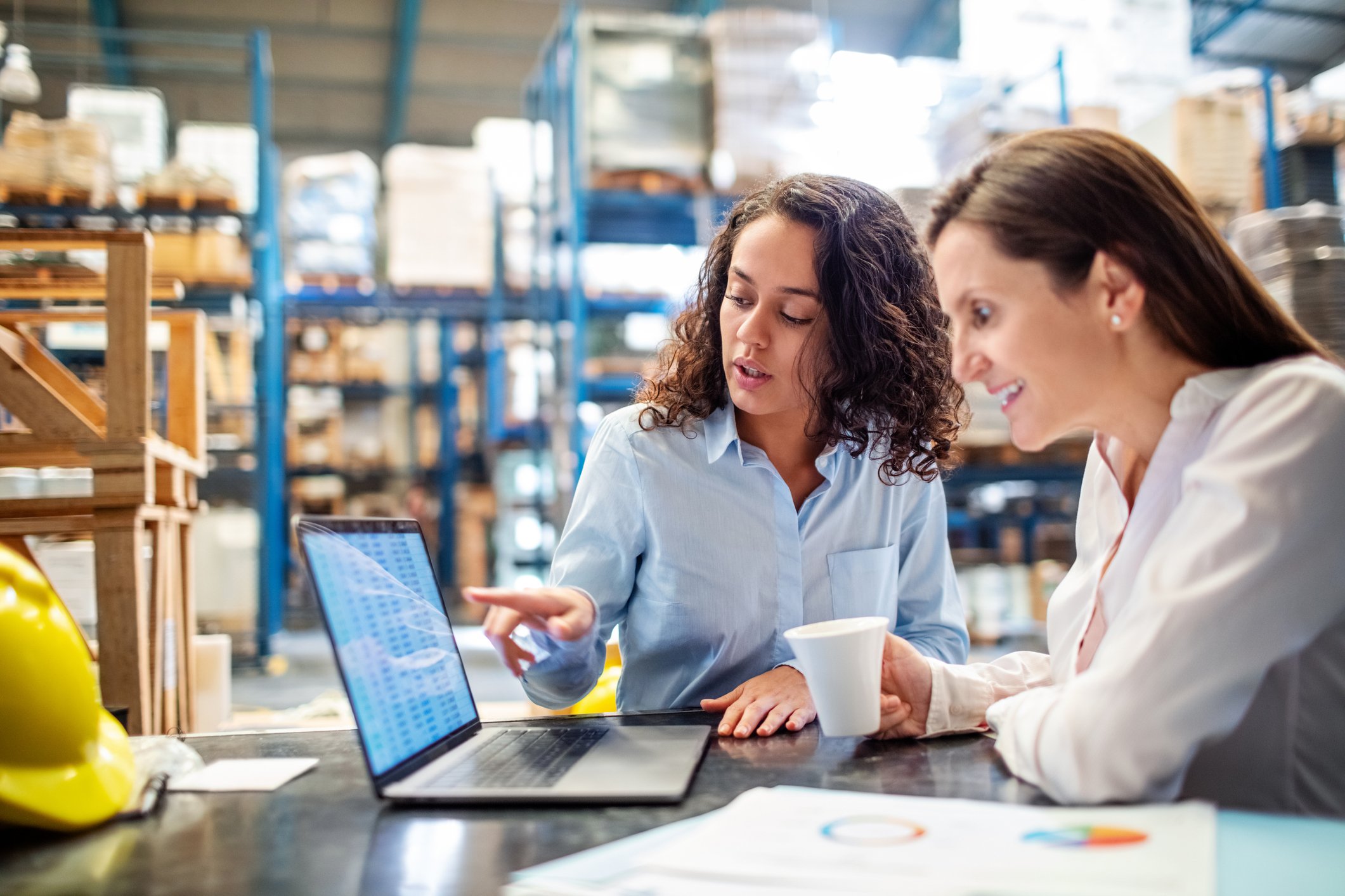 Two people looking at data on a computer in a warehouse.