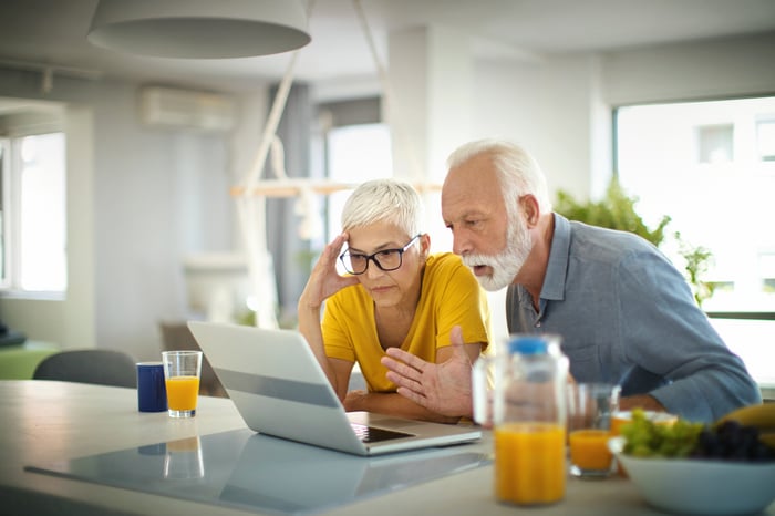 Worried couple looking at laptop.