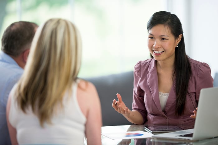Three people talking in office.