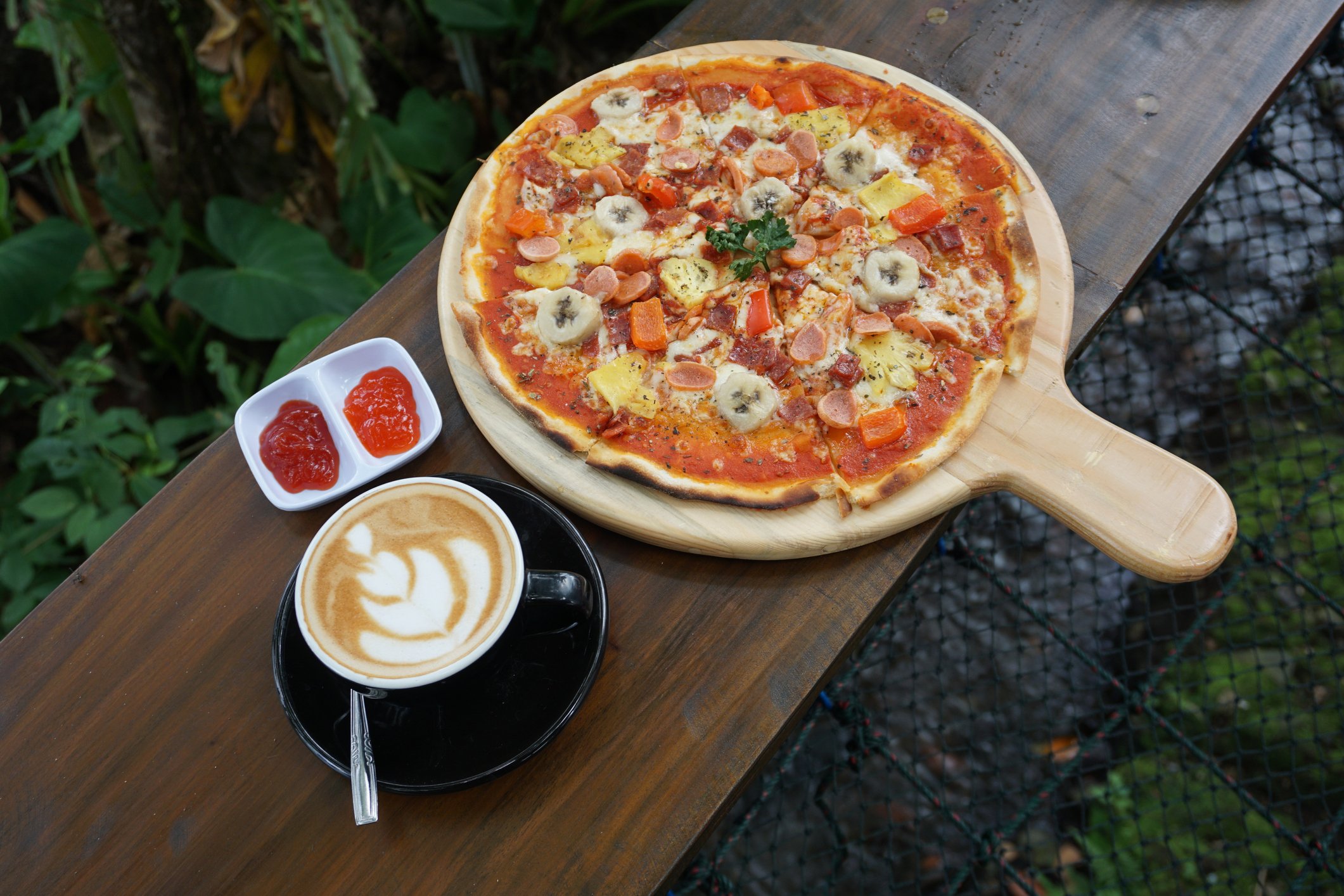 A pizza with a cup of coffee.
