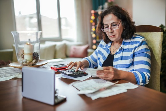 A person at desk, using calculator. 