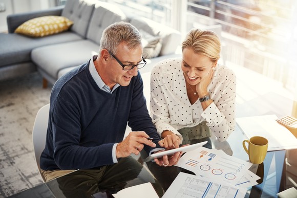 Two people at desk looking at charts.