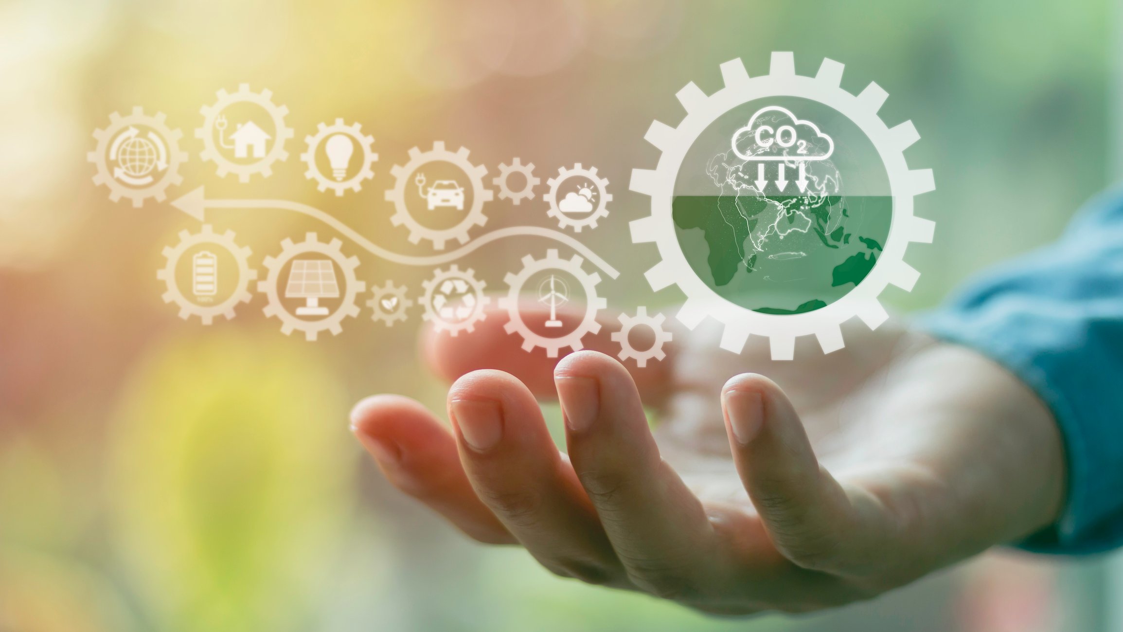 An outstretched hand holds various icons that symbolize carbon capture and sustainability. 