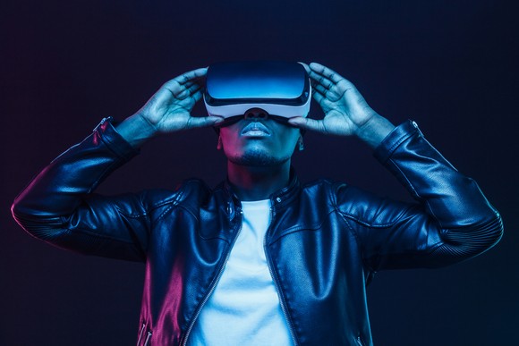 A person holding VR goggles.