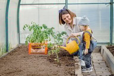 A parent and child do garden work.
