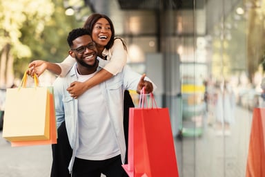 _couple with shopping bags pointing at window 