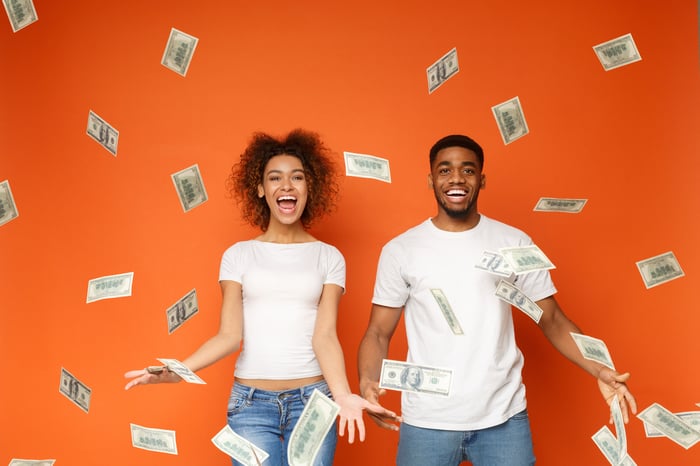 A happy couple is showered with cash.