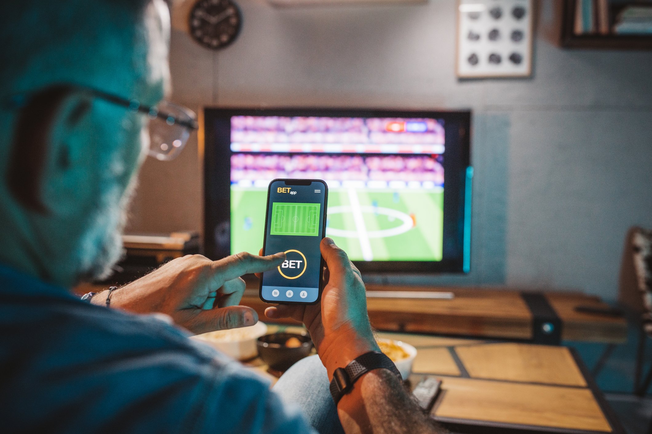 A person watching game, using sports betting app.