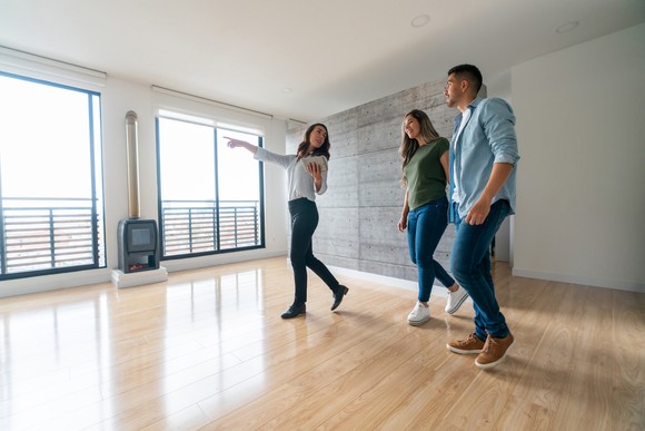 Couple walking through an empty house with a realtor.