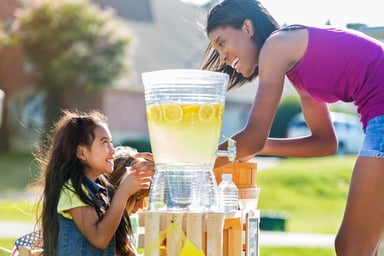 Person buying Lemonade from a kid at a stand