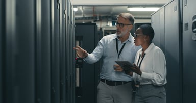 Two colleagues conferring in a server room