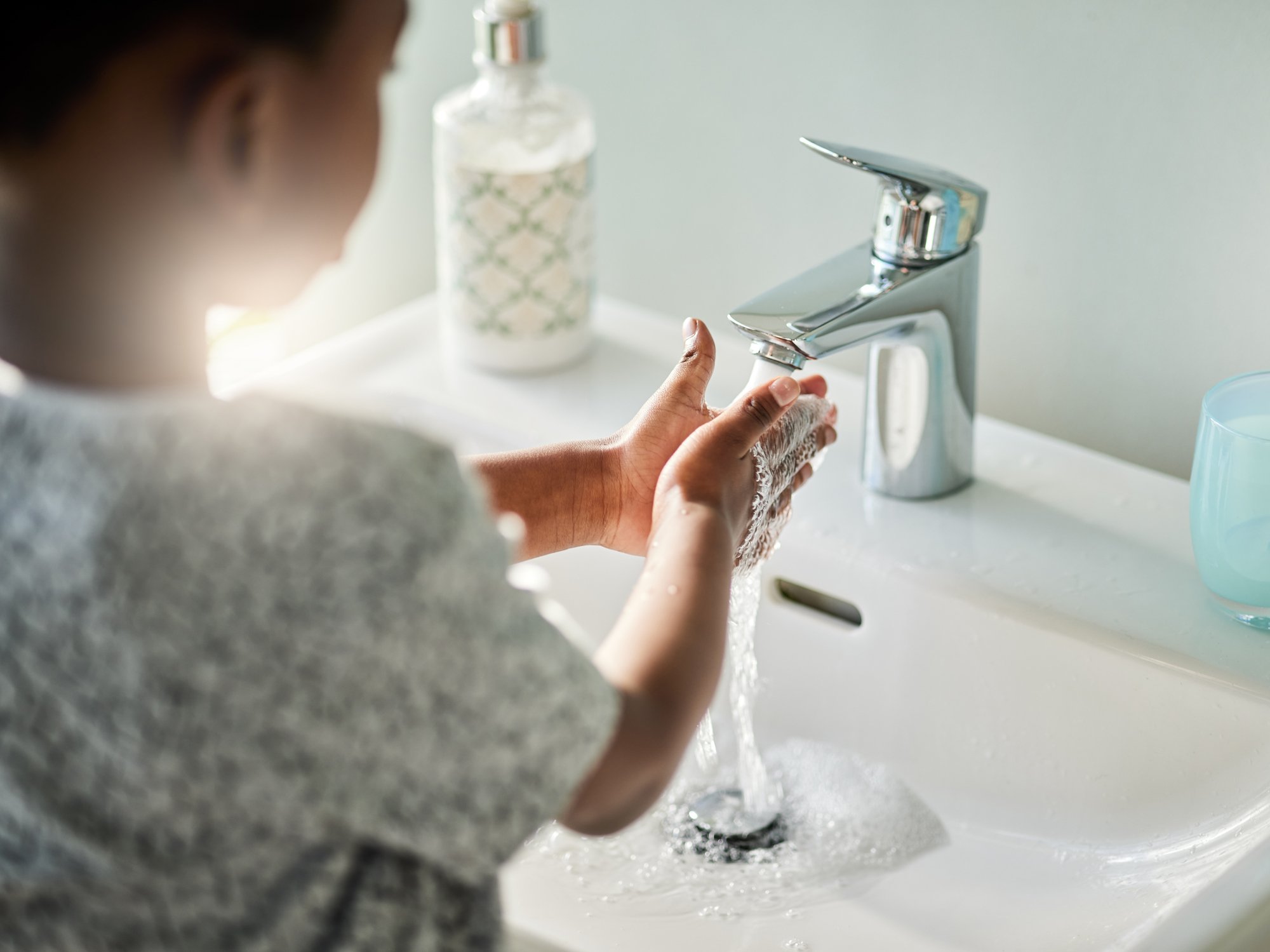 child washing hands at sink