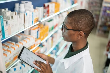 pharmacist in pharmacy looks at tablet