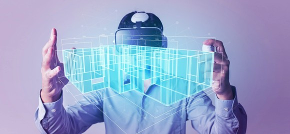 A person studies a VR model of a house.