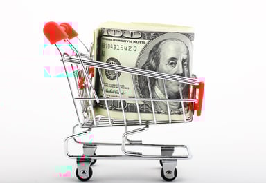 Money in a miniature shopping cart.